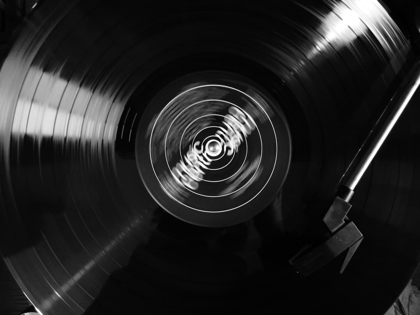 Un disco in vinile gira su un giradischi con il braccio inserito.