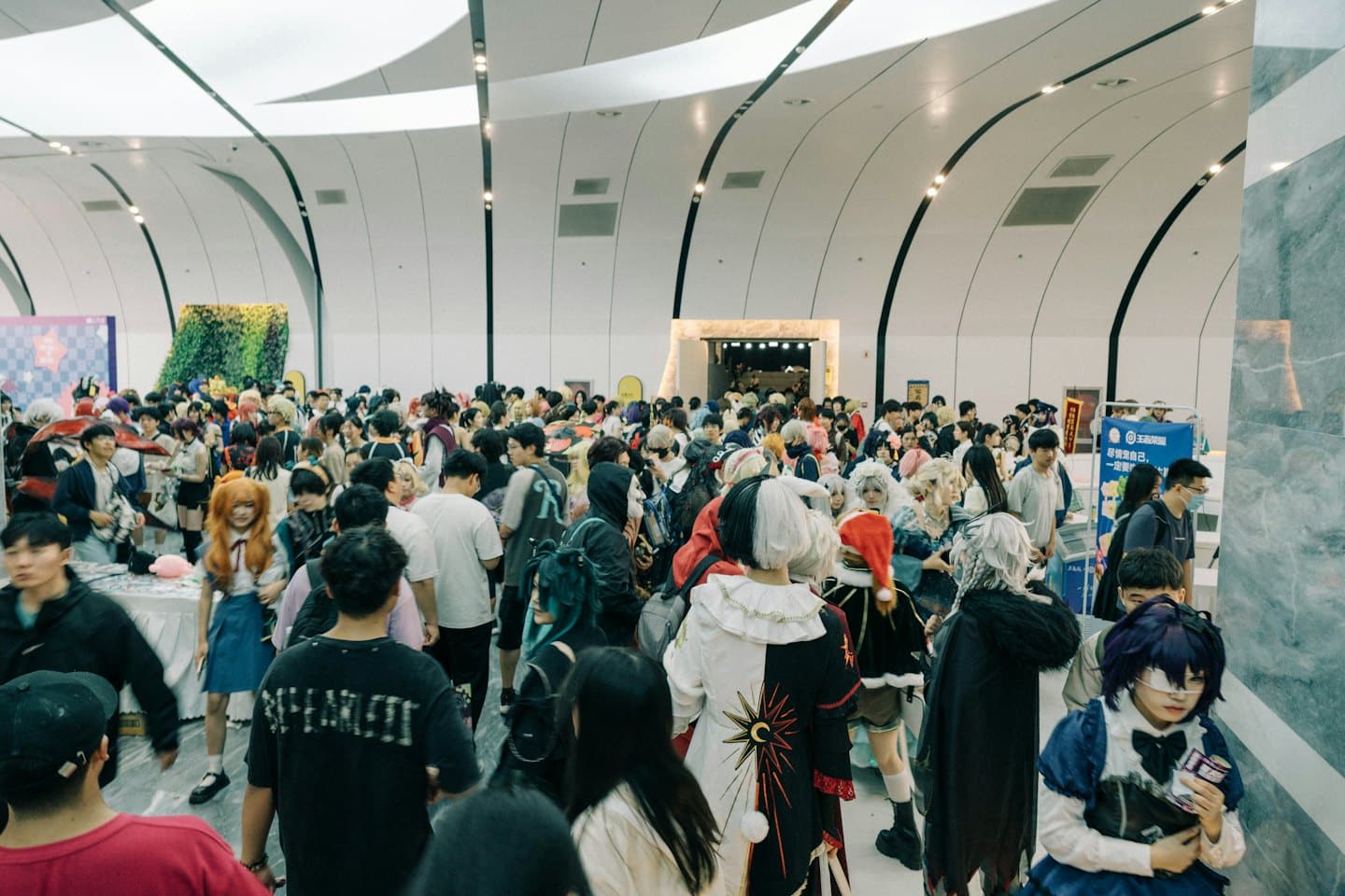 Persone in costume passeggiano in un moderno centro congressi.